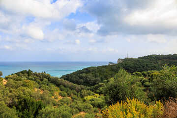 Fototapeta na wymiar View over wooded mountains and olive plantations to Cape Drastis in the north of the island of Corfu