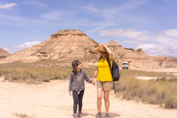 Mother and girl holding hands strolling for a national park