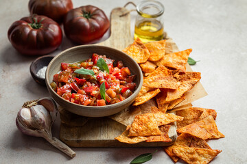 tartare de tomates à l'huile d'olive, ail et sauge avec des chips de tortilla maison au paprika