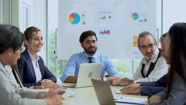 young indian business manager man talking or debate to colleagues in meeting on table with data in office. angry leader presentation explain and answer questions coworker