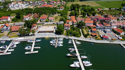 Panoramic aerial photo from drone to Mikolajki townscape - capital of Masurian region on the shore of the holiday resort beautiful summer afternoon. Mikolajki, Mikołajki, Poland, Europe.