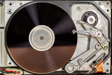 Interior of an old hard drive with its spinning platters and read head to the side