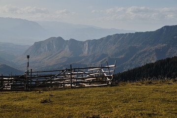 Empty pasture in the mountains. The fenced enclosure stands empty, ready to welcome a flock of...