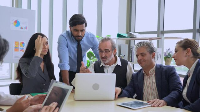 group of diverse business people working together looking laptop computer discussing on table in meeting room . senior manager caucasian indian worker and Hispanic or latino woman