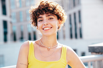 Young beautiful smiling hipster woman in trendy summer clothes. Carefree woman with curls...