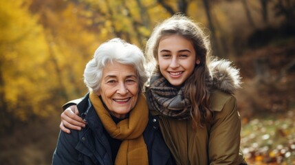 Grandmother and granddaughter walk in a park in nature in autumn on a sunny day, connection between generations, spending time with family - obrazy, fototapety, plakaty