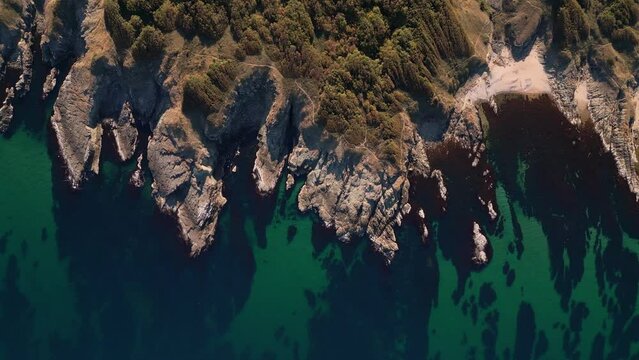 Aerial view of the rocky, wild coast of the Black Sea in Bulgaria, with cliffs, beaches, and green forests