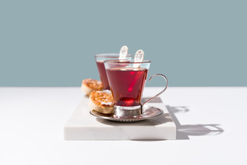 Dos tazas de té rojo con galletas sobre mármol 