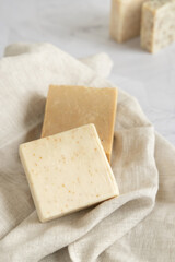 Beige handmade soap bars on cream linen towel close up
