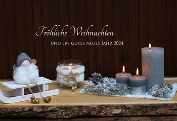 Weihnachtskarte:  Engel auf einem Schlitten mit Kerzen und dem Text Fröhliche Weihnachten und ein gutes neues Jahr 2024.