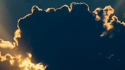 Vue rapprochée de sommets de cumulonimbus, illuminés par le soleil couchant, juste derrière