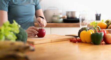 Woman asian cutting fruits and vegetable to prepare a smoothie in the kitchen at home