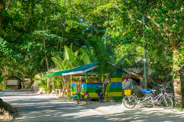 Bikes and beach bar on the road of La Digue island, Seychelles - obrazy, fototapety, plakaty