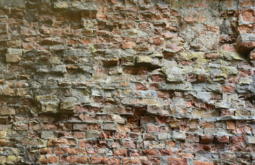 Very old brick stone wall of castle or fortress of 18th century. Full frame wall with obsolete dirty and cracked bricks close up