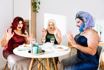 Excited transgender women sitting at served table