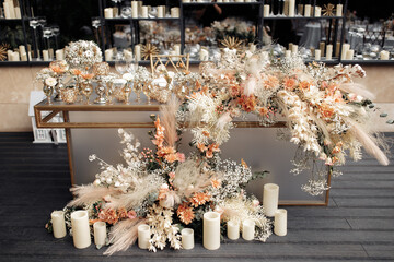 Front view of glamour table against mirrored wall with floating candles. Modern luxury wedding decor in expensive tones.