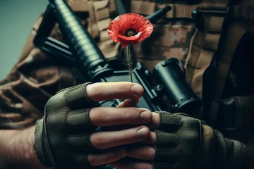 Papier Peint photo Canada Soldier hands holding gun and one wild red poppy flower. Remembrance Day, Armistice Day, Anzac day symbol