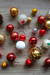 Pine cones and red, golden and white Christmas ornaments on wooden background. Top view.