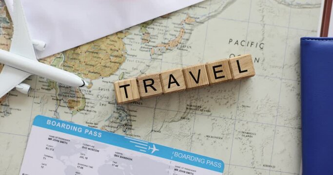 Aircraft and international passport on World Map in travel company. Travelling around world via tourist agency. Wooden blocks with inscription Travel