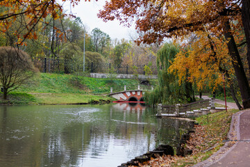 Autumn landscape with a river and a bridge in the city park