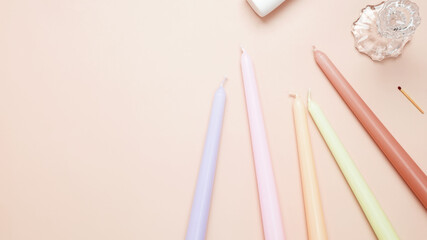 Set various antique long candles on a beige background. Top view, copy space, flat lay