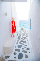Woman in red dress at the Streets of old town Mykonos during a vacation in Greece, Little Venice Mykonos Greece