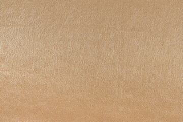 Fototapeta na wymiar Close-up texture of a shiny beige fabric made of synthetics. Fabric for sewing suits, clothes. Elegant background for your design