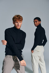 handsome african american man standing next to red haired bearded man posing and looking at camera