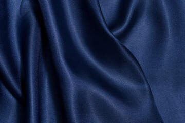 Close-up texture of crumpled fabric of deep blue color with shine close-up. Background for your design