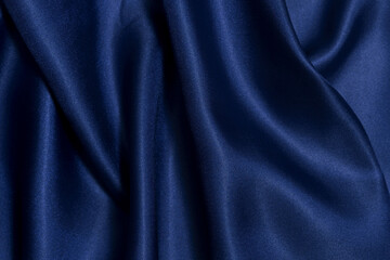 Close-up texture of wrinkled, crumpled fabric of blue color with glare and shadows. Image for your design