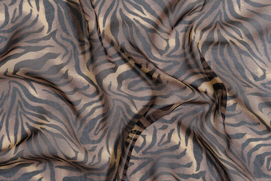 texture of transparent chiffon fabric of leopard or tiger color. Image for your design. materials for sewing