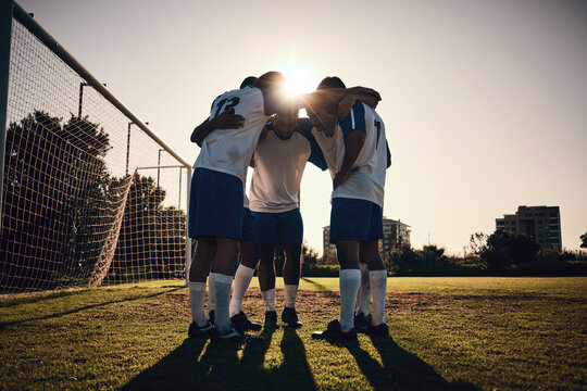 Soccer, sunset or team in a huddle for motivation, goals or group mission on stadium field for a sports game. Match, sunshine or football players planning a strategy, exercise or training for fitness
