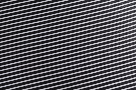 close-up texture of black and white striped silk fabric at an angle. Tailoring concept. Image for your design