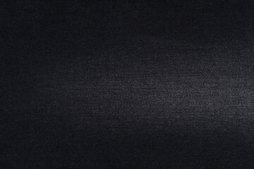 Close-up texture of black denim with fraying. The concept of materials for sewing jeans. Mockup for your design