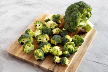 Organic Raw Broccoli Florets on a wooden board, side view.