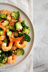 Homemade Garlic Broccoli Shrimp Stir Fry on a Plate, top view. Flat lay, overhead, from above. Copy space.