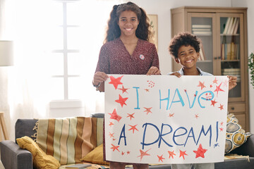 Portrait of smiling brother and sister holding I have a dream placard created for Martin Luther...