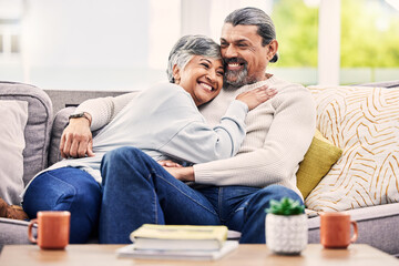 Happy, hug and senior couple relax on a sofa with love, bond and laugh with conversation. Old people, living room and embracing with smile, trust and soulmate connection while enjoying retirement