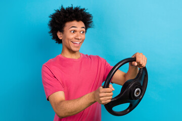 Photo of astonished positive guy wear pink t-shirt hold steering wheel staring at offer empty space...