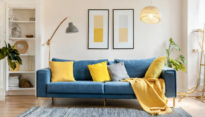 Blue sofa with yellow pillows and blanket against beige wall with frame poster scandinavian