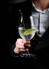 side view of transparent cocktail with ice on a dark background