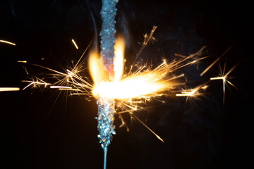 sparks from a burning sparkler on a black background.