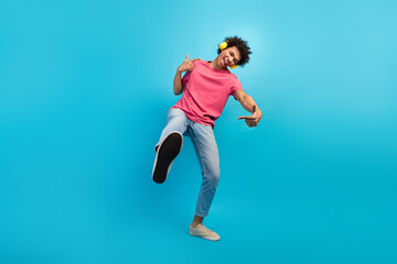 Full body photo of handsome young male dancer yellow earphones excited dressed stylish pink outfit isolated on blue color background