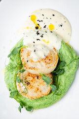  cheesecakes with creamy sauce on broccoli puree, side view