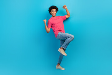 Fototapeta na wymiar Full size photo of handsome young male raise fists celebrate lottery winning wear trendy pink outfit isolated on blue color background