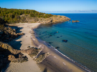 Aerial view of the rocky, wild coast of the Black Sea in Bulgaria, with cliffs, beaches, and green forests