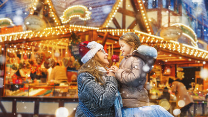 Happy mother and daughter eat a red sugar apple at the traditional German Christmas market.