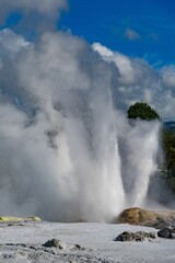 Geyser erupts and disperses a powerful stream of water into the air.