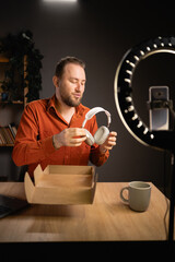 Attractive man blogger broadcasting a video for selling or unboxing product online. Shopping online...