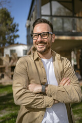 One adult man stand outdoor in front of his house happy confident